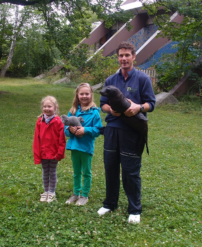 Tierpfleger Andreas Fackel mit dem Seelöwenjungtier Mia und Lea Nettersheim (Mitte), Namensgeberin für den kleinen Seelöwen. Links ihre Schwester Johanna Nettersheim. 
