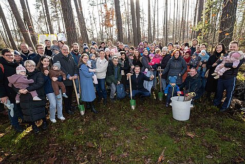 Rund 30 Familien mit berbürgermeister Marcus König, Bürgermeister Christian Vogel und Fachleute des Tiergartens der Stadt Nürnberg und des Amts für Ernährung, Landwirtschaft und Forsten in einem Wald bei Königshof.